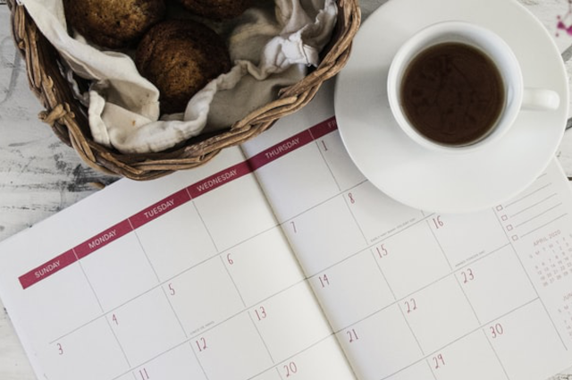 A calendar with a cup of tea on top